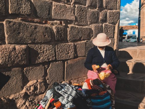 Kobieta sprzedaje coś na ulicy w Cusco