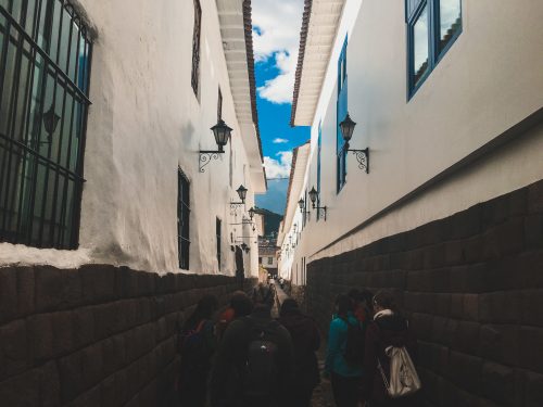 Uliczka w Cusco z białymi murami i błękitnym niebem