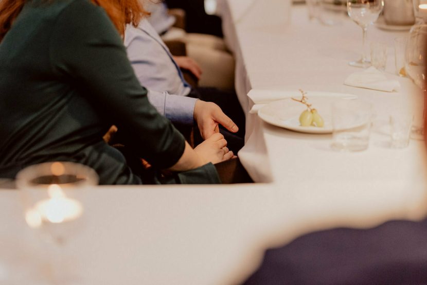 Para trzyma się za dłonie przy stole