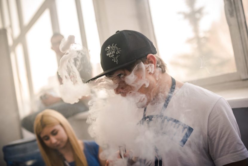 A boy in a black cap in a cloud of smoke