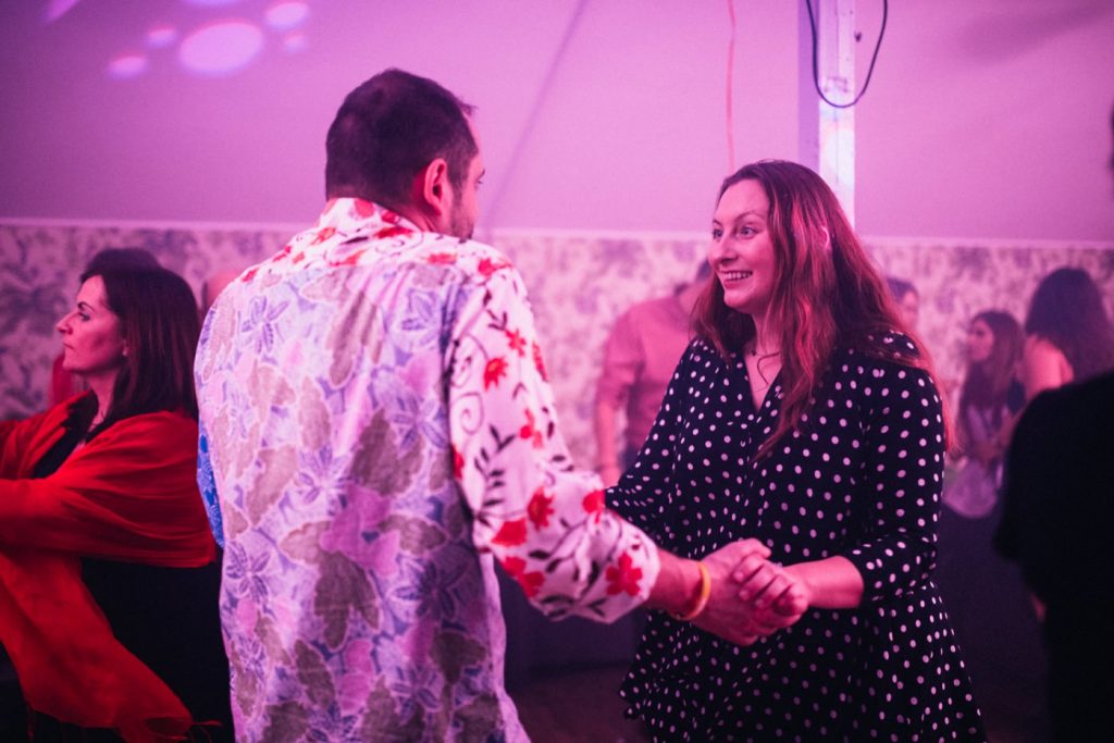A couple in patterned shirts dances on a parkeit