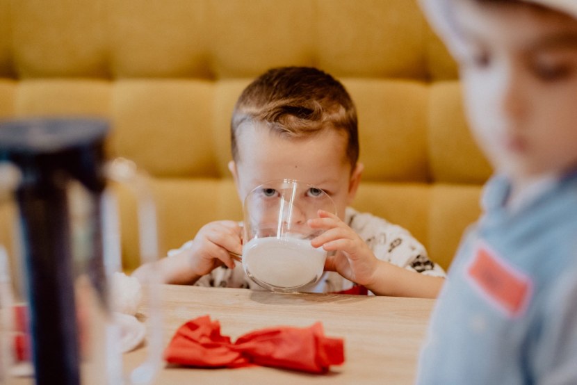 A child drinks milk from a large cup