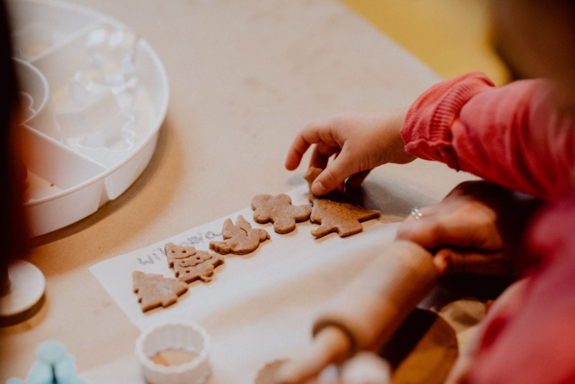 The child arranges the cut gingerbread on baking paper