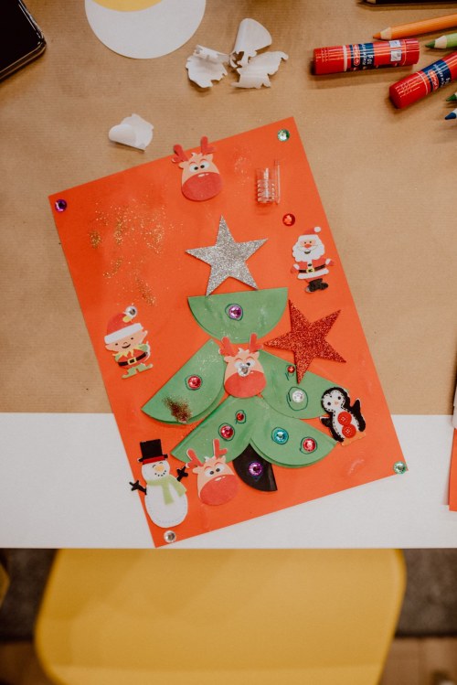 Świąteczna choinka zrobiona z papieru na pomarańczowym arkuszu papieru