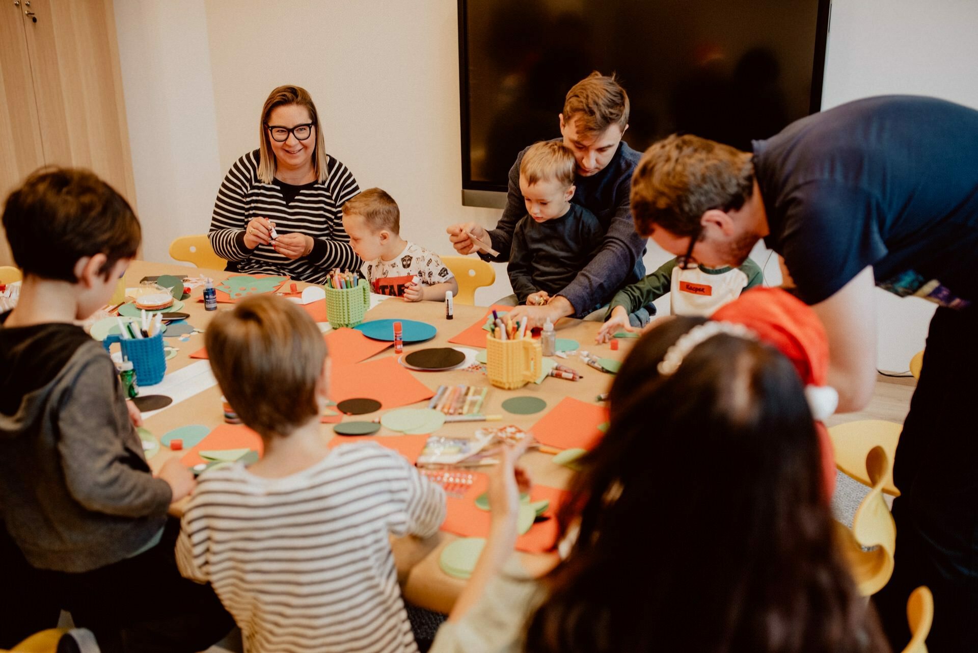 Children cut out Christmas decorations with their parents