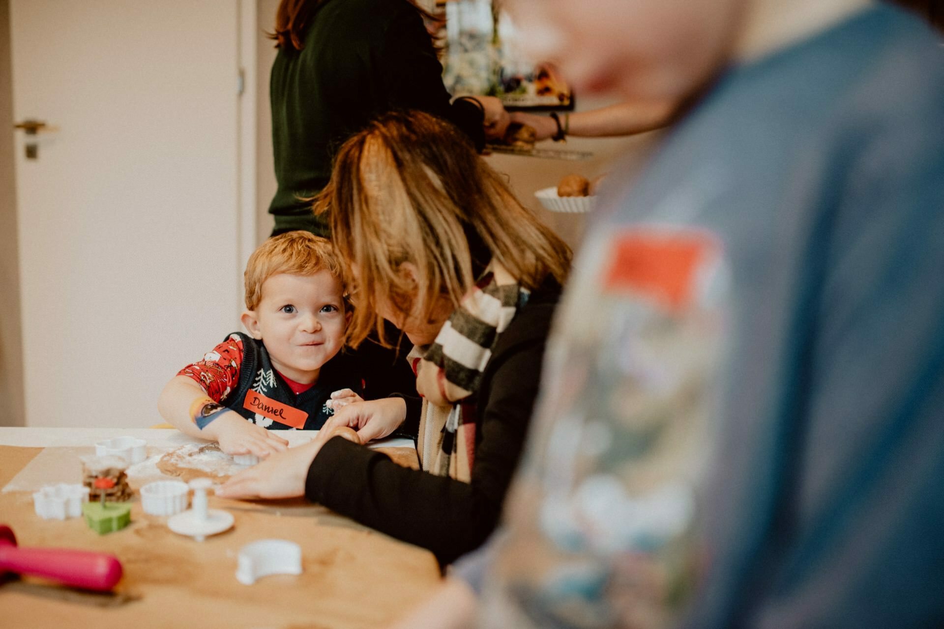 A child sticking gingerbread with his mother at the table