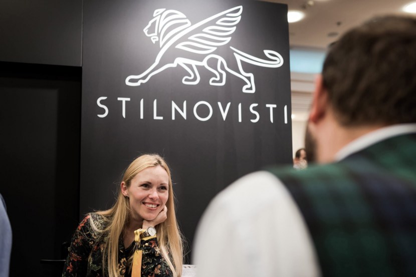 Smiling blonde on the background of the Stilnovisti logo