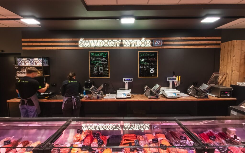 Virtual walk through the organic grocery store Smak Natury 4 - Urbanflavour.pl Meat and deli counter in the Smak Natury store with the sign Świadomy wybór above it